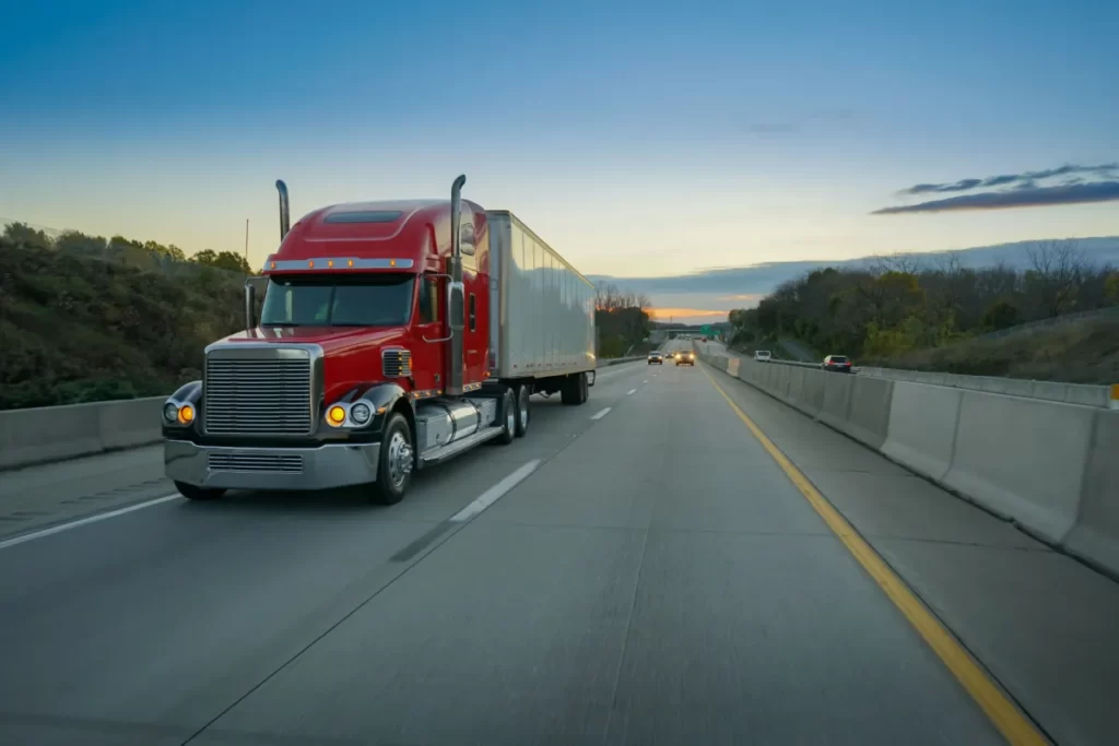 red tractor trailer driving on freeway