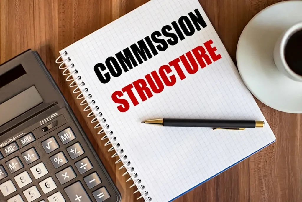 Pen on notebook labeled commission structure beside a calculator on a wooden desk with a coffee cup.